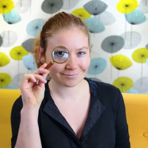 Judith Schneider mit Lupe vor dem Auge